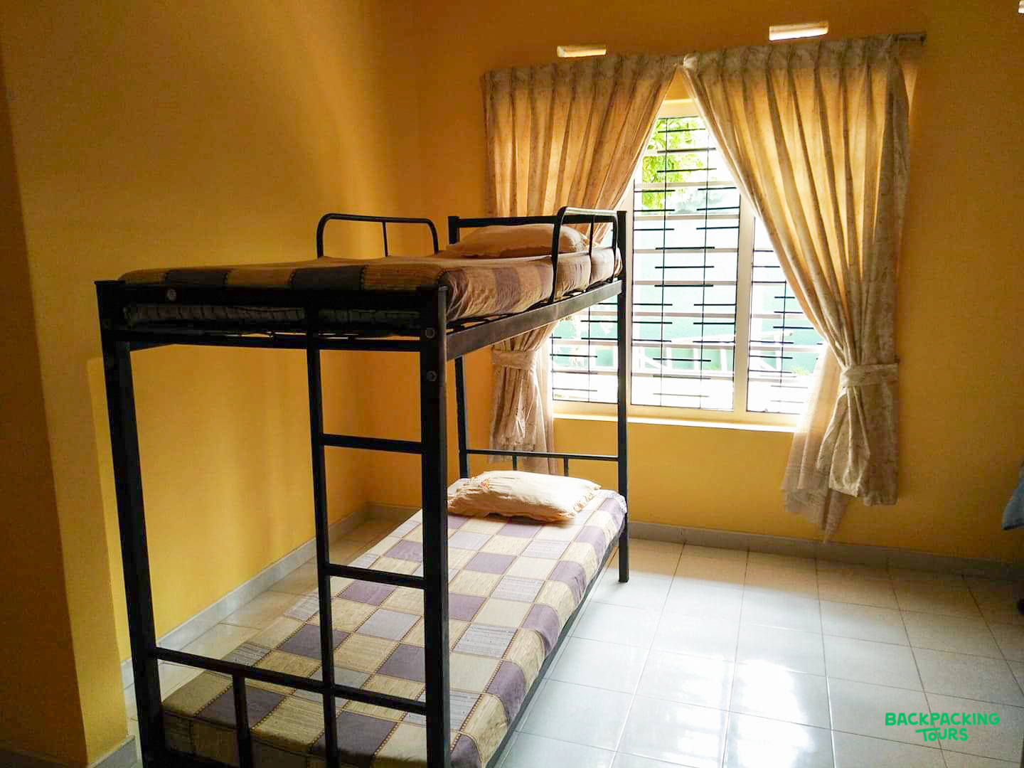 Your comfortable shared room with a sturdy metal bunk bed and a bright window.