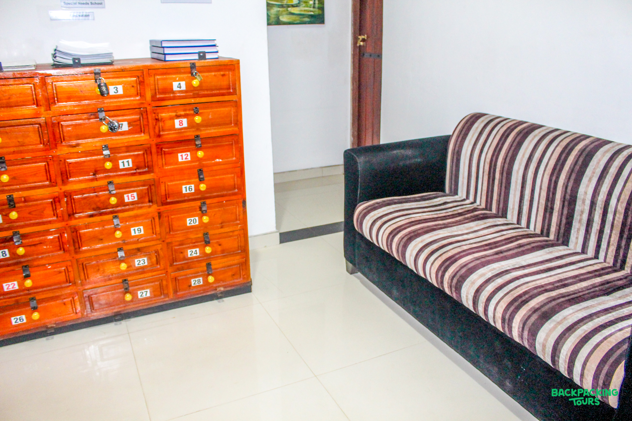 A comfortable striped sofa and a wooden locker unit in a shared living area.