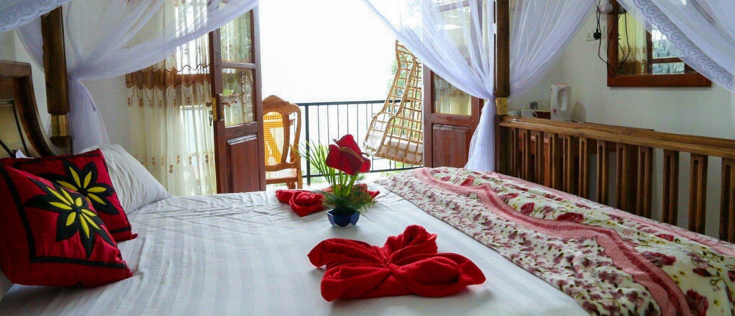 Beautiful hotel room with a large bed, decorative pillows, and a balcony with an expansive view.