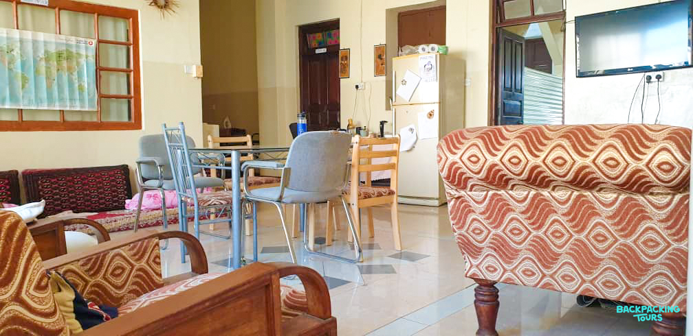 A welcoming communal living area with patterned sofas and a dining table in Zanzibar.