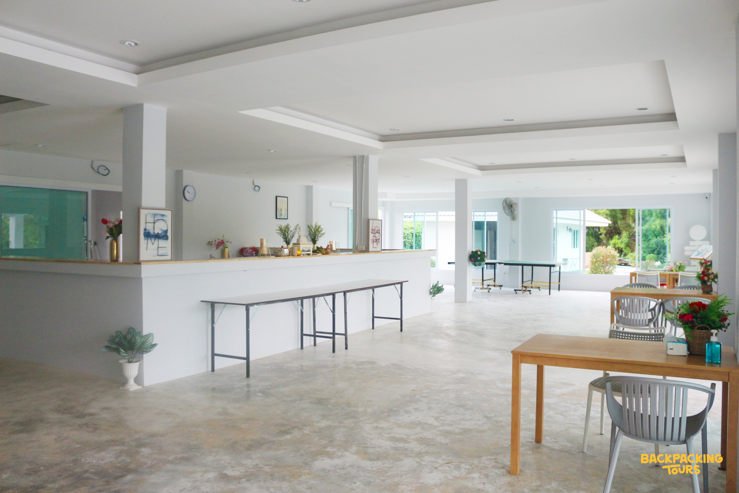 A welcoming, bright common area with dining tables and a service counter at the accommodation.