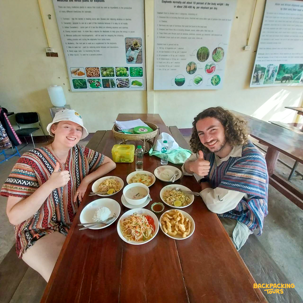 Smiling volunteers give thumbs up while enjoying a variety of authentic Thai dishes in Thailand.