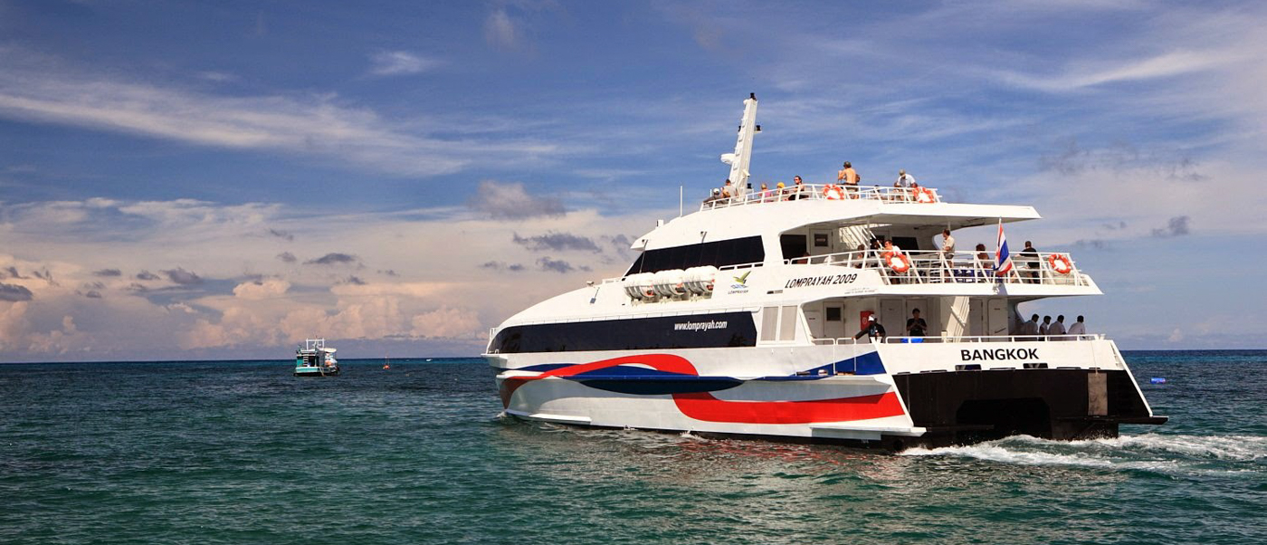 A large white ferry with red and blue stripes transports passengers across the ocean from Koh Phangan.