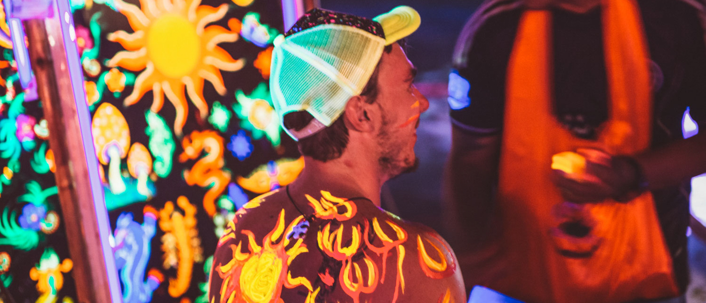 A person with glow-in-the-dark body paint and a neon cap at the vibrant Full Moon Party, Koh Phangan.