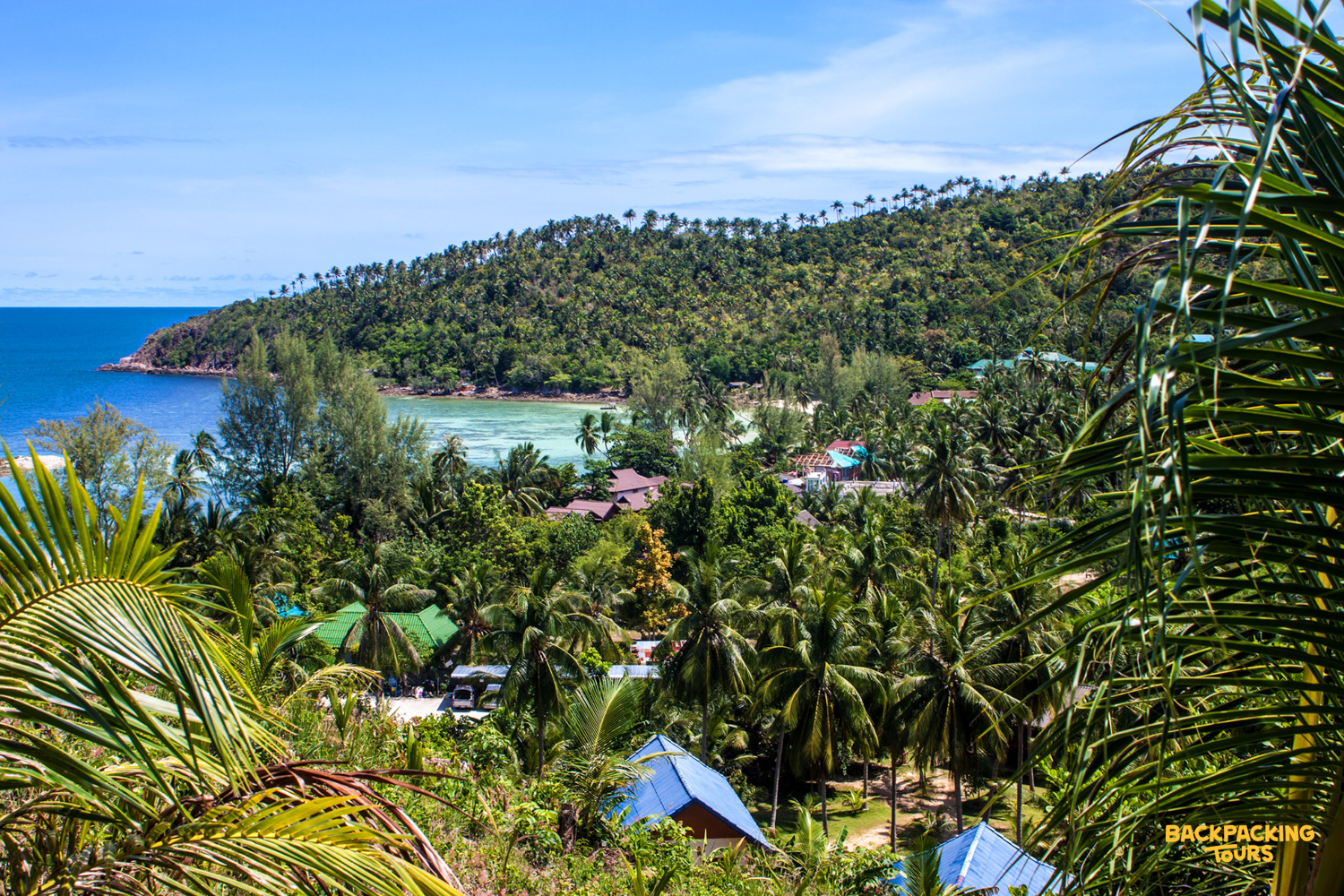 Relaxing tropical beach scene with clear turquoise water and lush green hills on Koh Phangan.