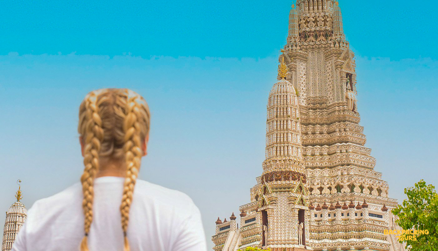 backpacker facing wat arun temple in bangkok