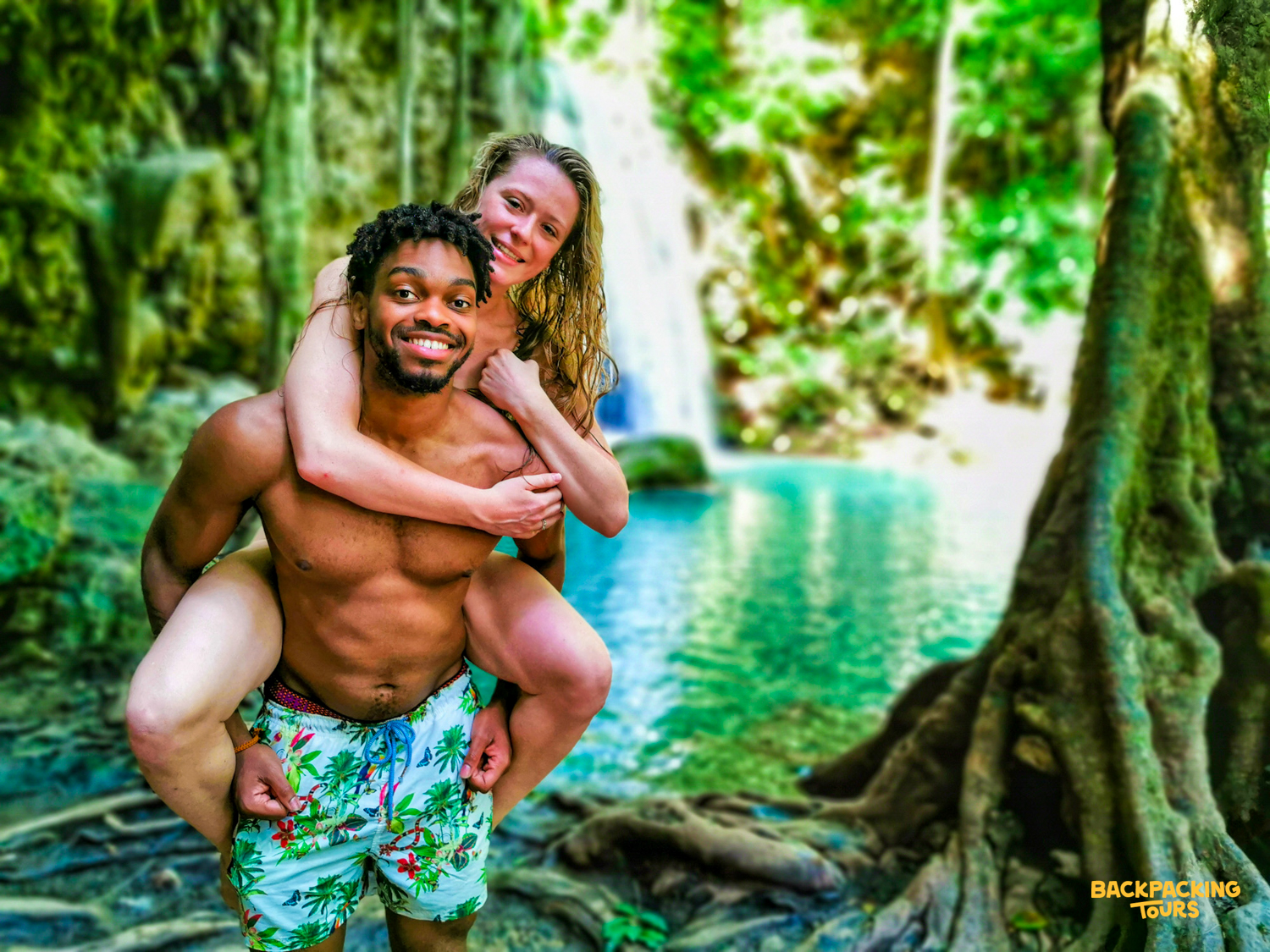 Two smiling travelers enjoy a piggyback ride in the emerald pools of Erawan Waterfalls.