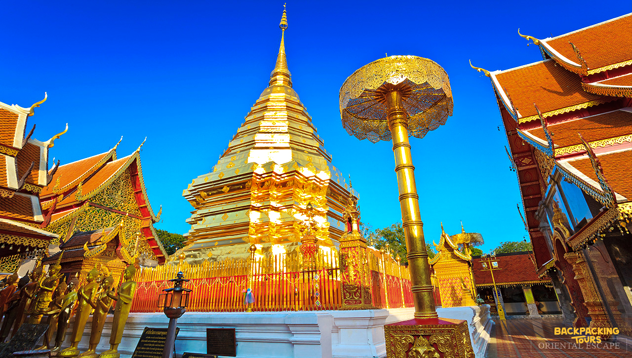 Magnificent golden temple spires of Doi Suthep gleam under a clear blue sky in Chiang Mai.