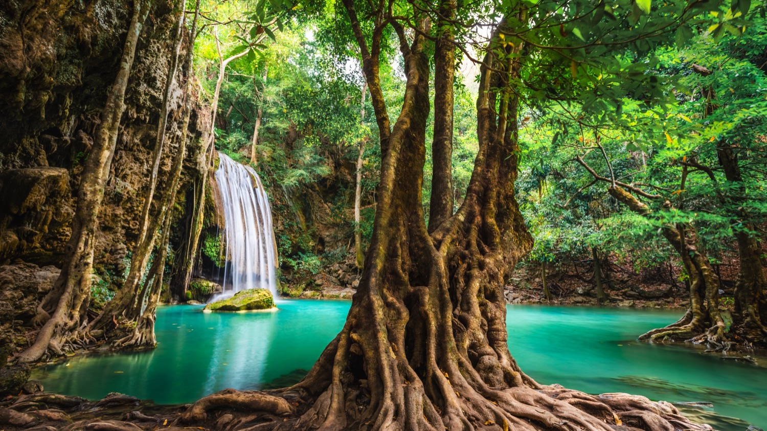 Erawan Falls in Thailand, a beautiful waterfall cascading into a vibrant turquoise pool.