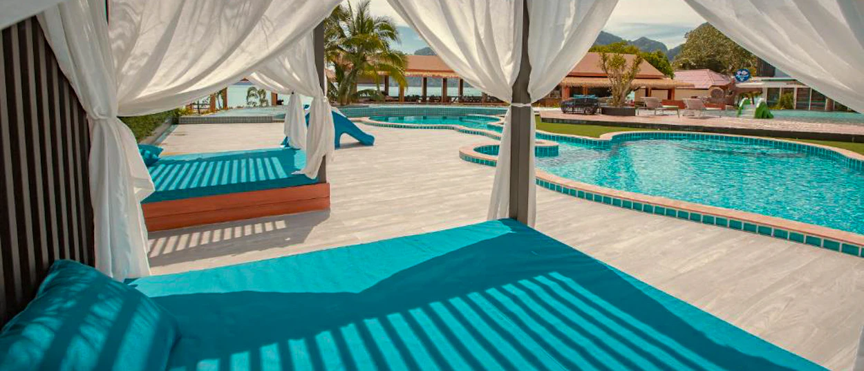 Sunny daybeds and sparkling blue swimming pools at a beautiful resort on Phi Phi Islands.