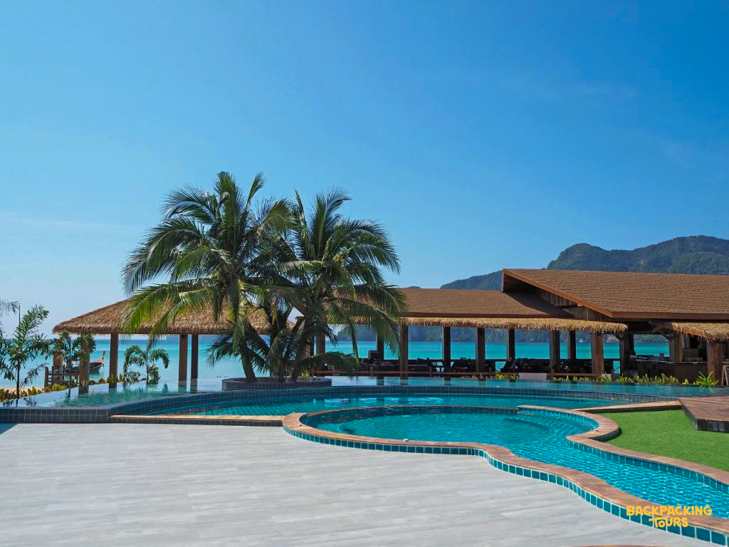 Tropical resort with a large swimming pool, palm trees, and ocean views on Phi Phi Islands.