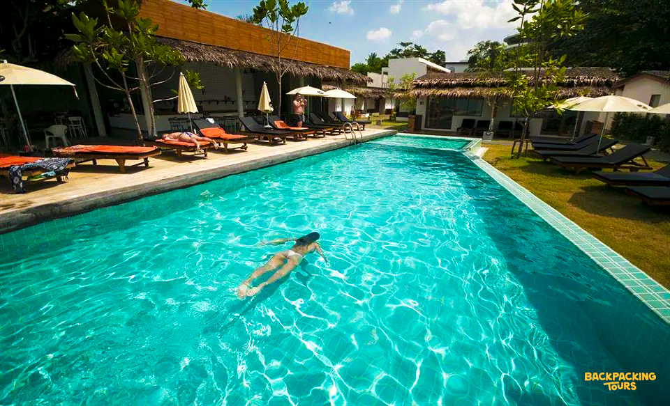 A woman swims in the refreshing resort pool on a sunny day in Koh Samui.