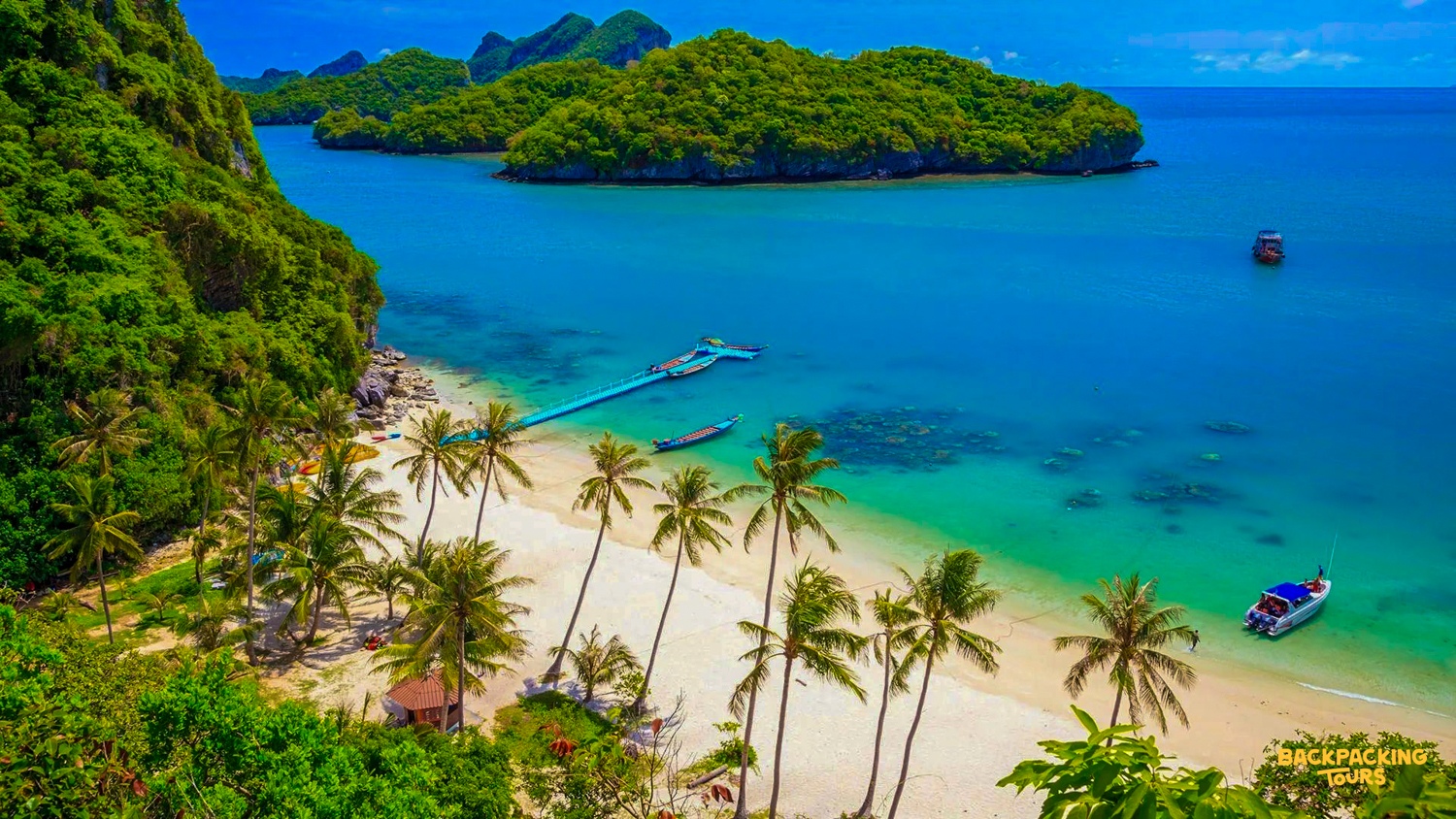 Beautiful white sand beach with palm trees, clear turquoise water, and lush islands on Koh Samui.