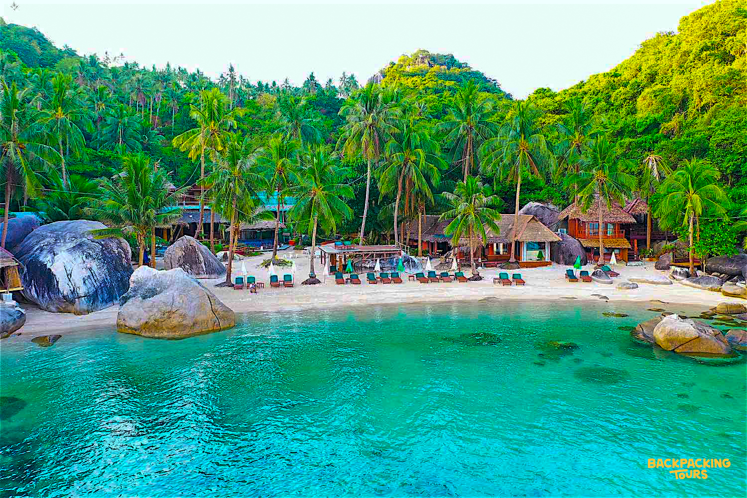 Stunning beach resort on Koh Tao with bungalows, palm trees, and crystal-clear turquoise water.