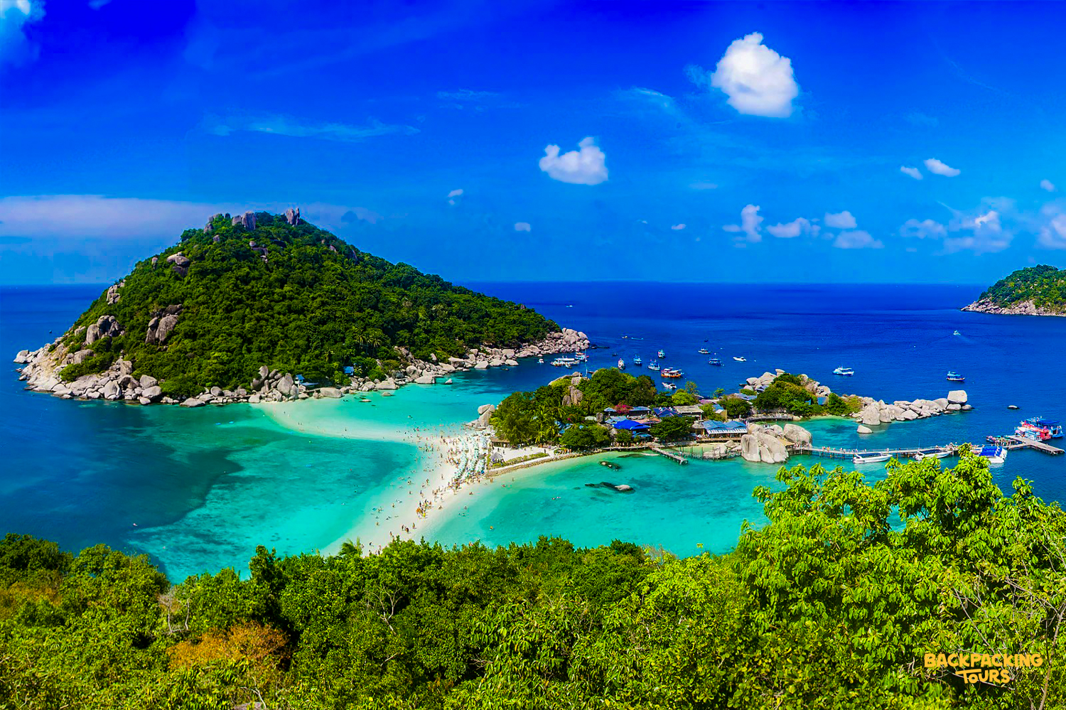 Idyllic tropical paradise with clear turquoise water, lush islands, and a connecting sandbar in Koh Tao.