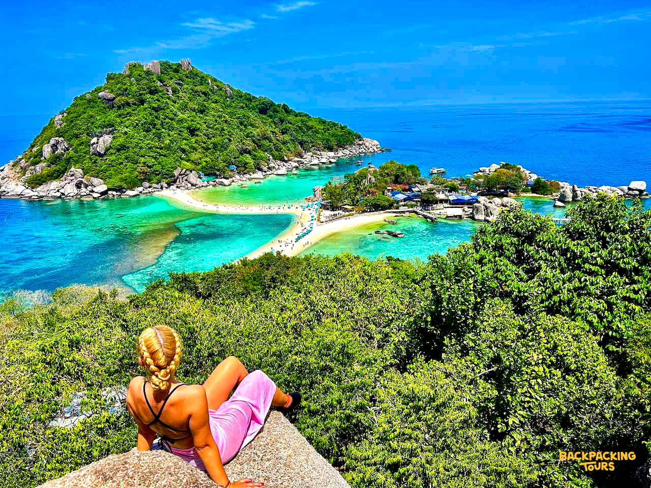A woman enjoys the breathtaking view of Koh Nang Yuan's connected islands and turquoise waters.
