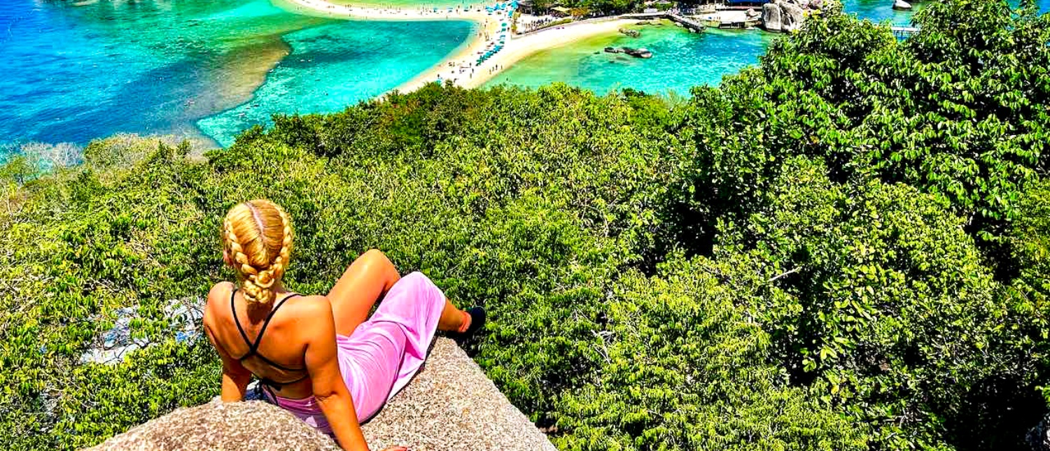 A woman with braided hair admires the iconic turquoise waters and sandbar of Koh Nang Yuan.
