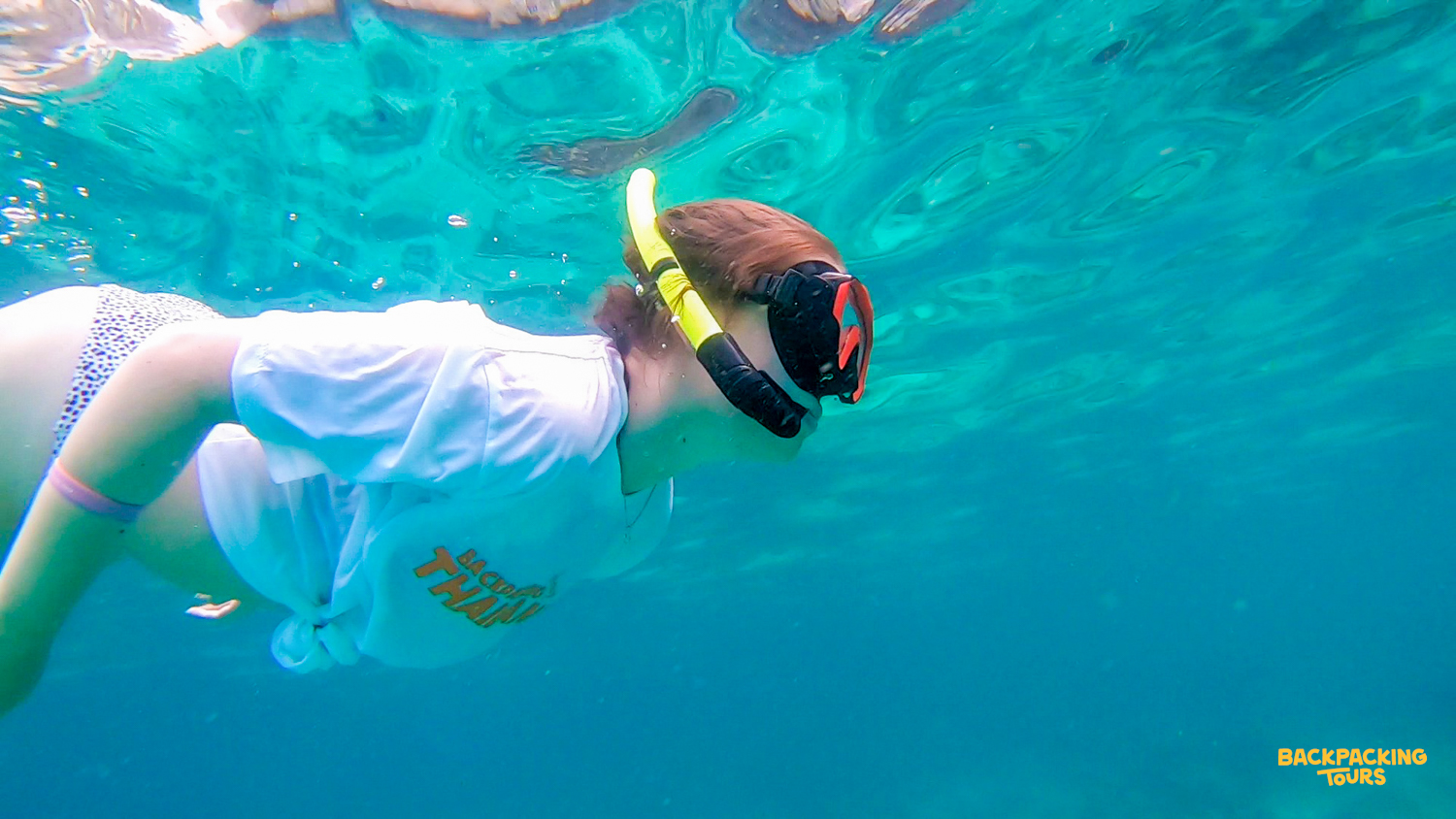 A traveler snorkeling in the clear blue waters of Phi Phi Islands, enjoying the island's beauty.