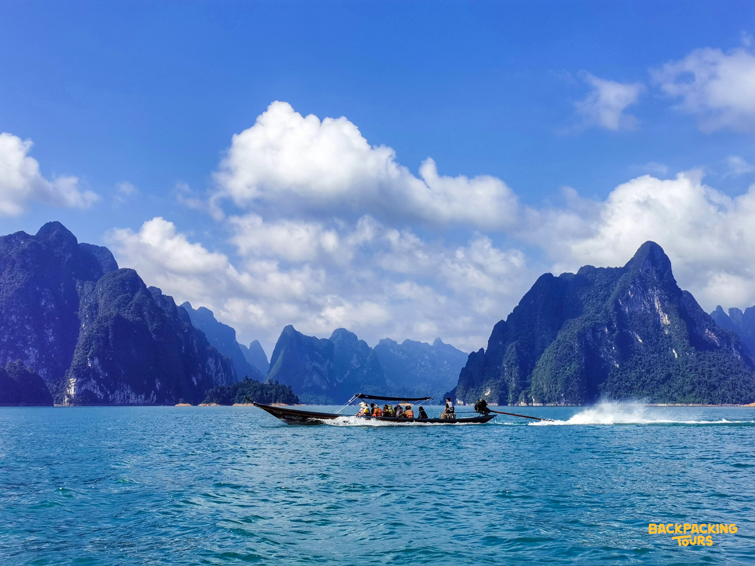 A longtail boat carries tourists across Cheow Lan Lake in Khao Sok National Park, Thailand.