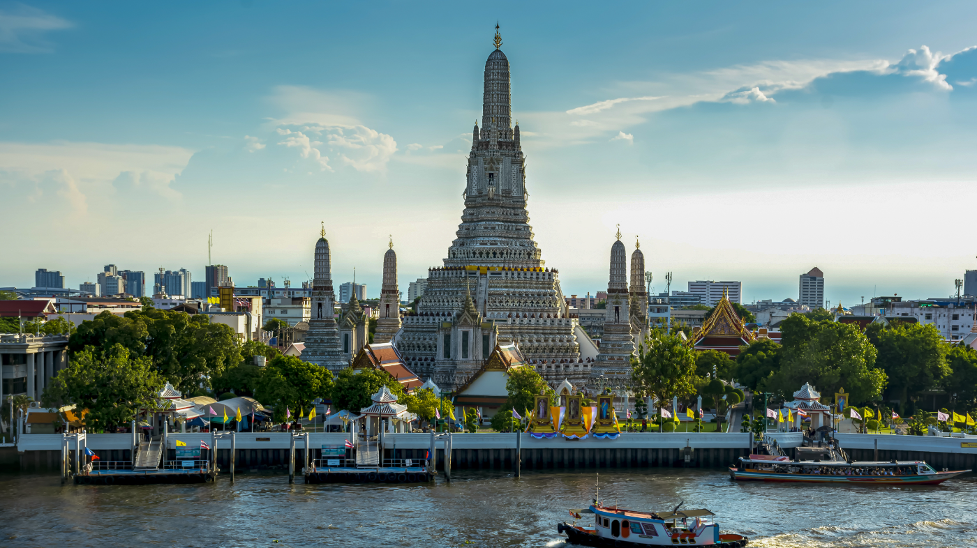 The majestic Wat Arun temple stands tall by the Chao Phraya River in Bangkok, Thailand.