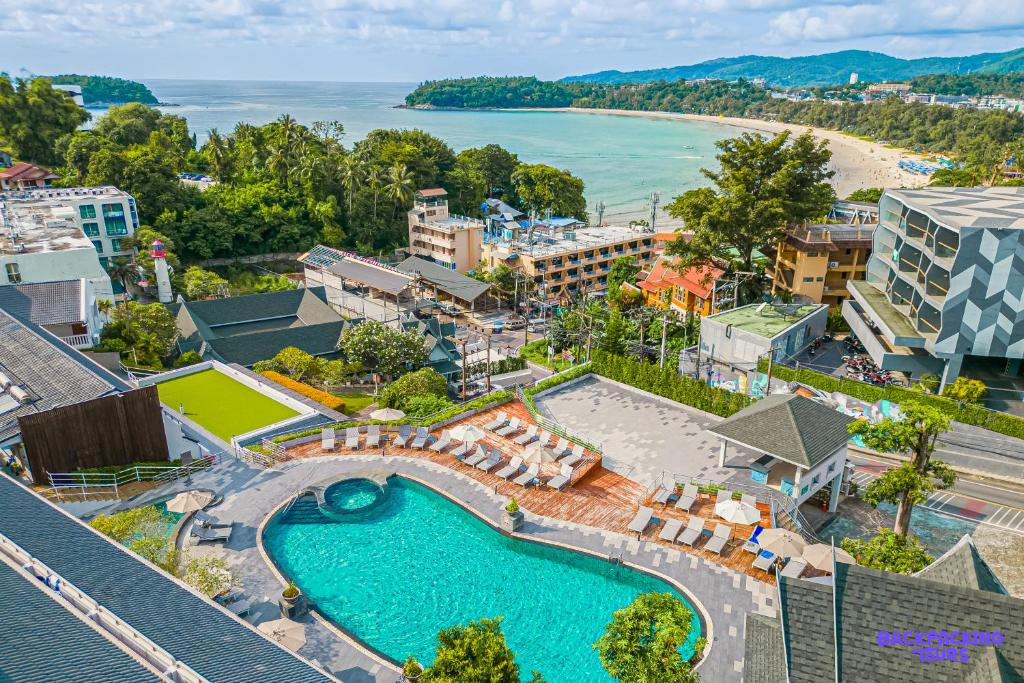 Relaxing resort pool area with lounge chairs, overlooking a wide sandy beach and ocean in Phuket.