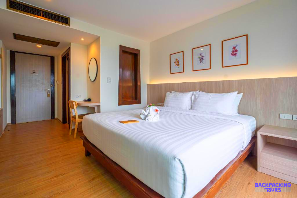 Inviting hotel room in Phuket with a large bed, wooden floor, and a charming towel animal.