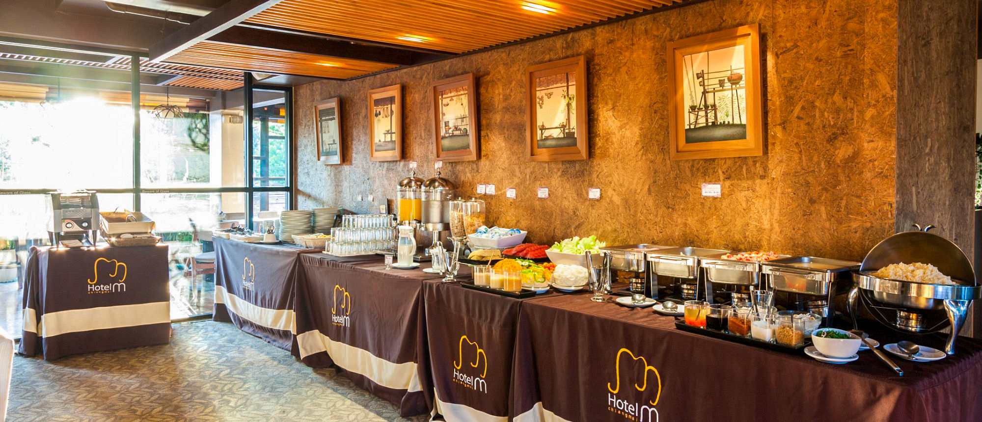 A vibrant breakfast buffet with various dishes, fresh fruits, and juices at a hotel in Chiang Mai.
