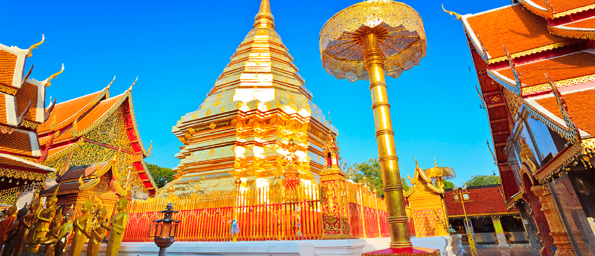 Golden chedi of Wat Phra That Doi Suthep temple in Chiang Mai under a clear blue sky.