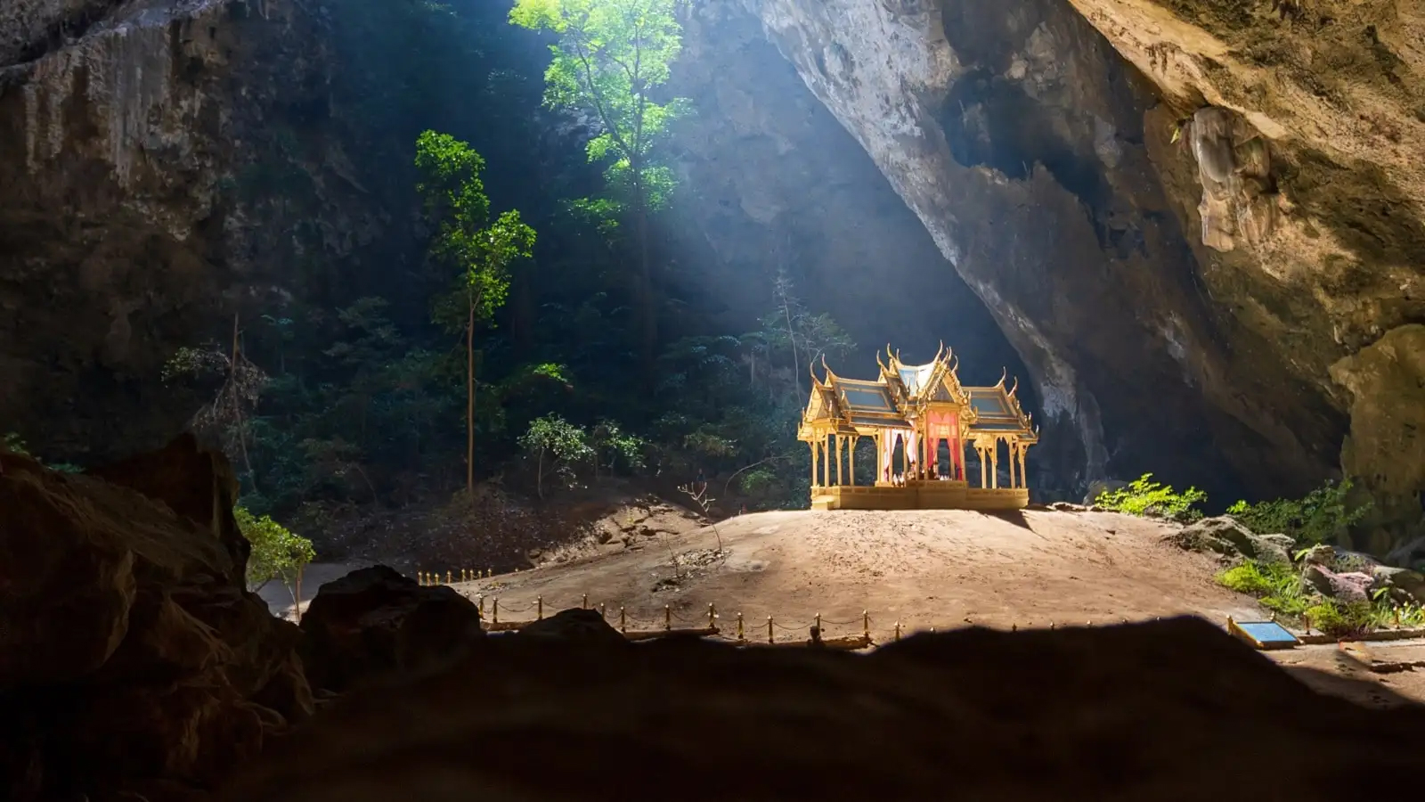The stunning Kuha Karuhas Pavilion glows under a sunbeam inside Phraya Nakhon Cave, Thailand.