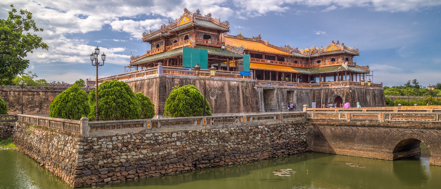 Ornate imperial citadel with traditional architecture, surrounded by a moat and stone bridge in Hue.
