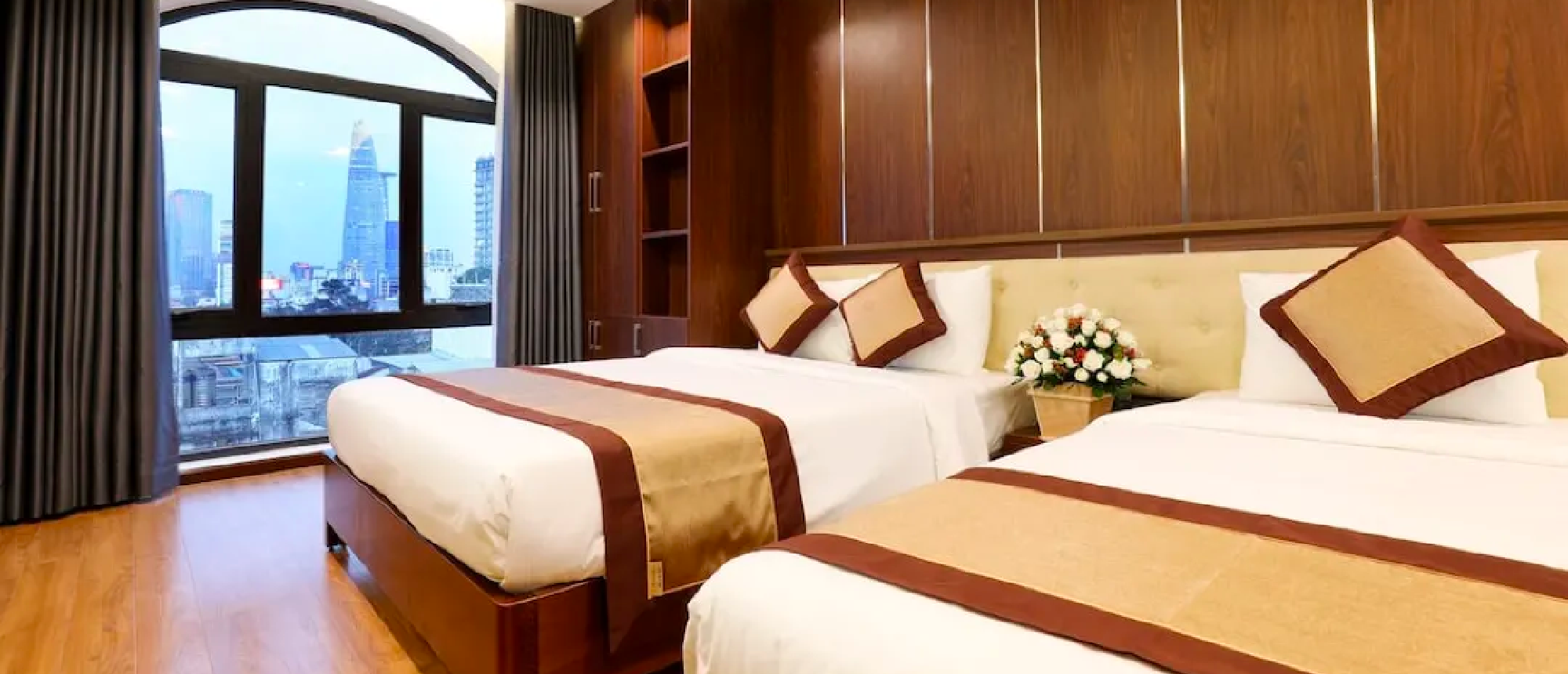 A comfortable hotel room in Ho Chi Minh with two beds and a modern city view.